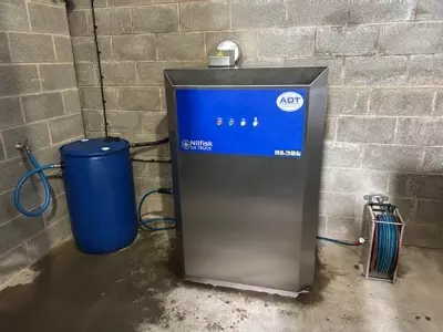 Nilfisk SH Truck stainless static hot pressure washer installed at a Twycross farm for cleaning ATV equipment, with 200L water barrel and boost pump modification.